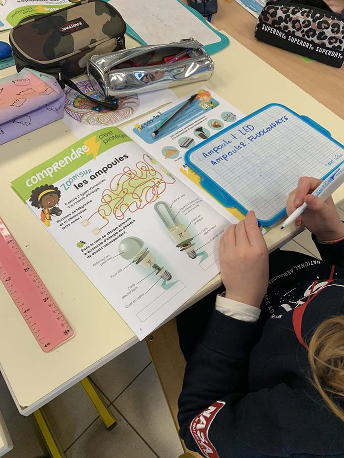 Cahier d'activités ouvert sur une table d'école